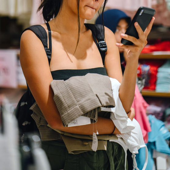 woman-shopping-fast-fashion-clothing-while-on-her-phone